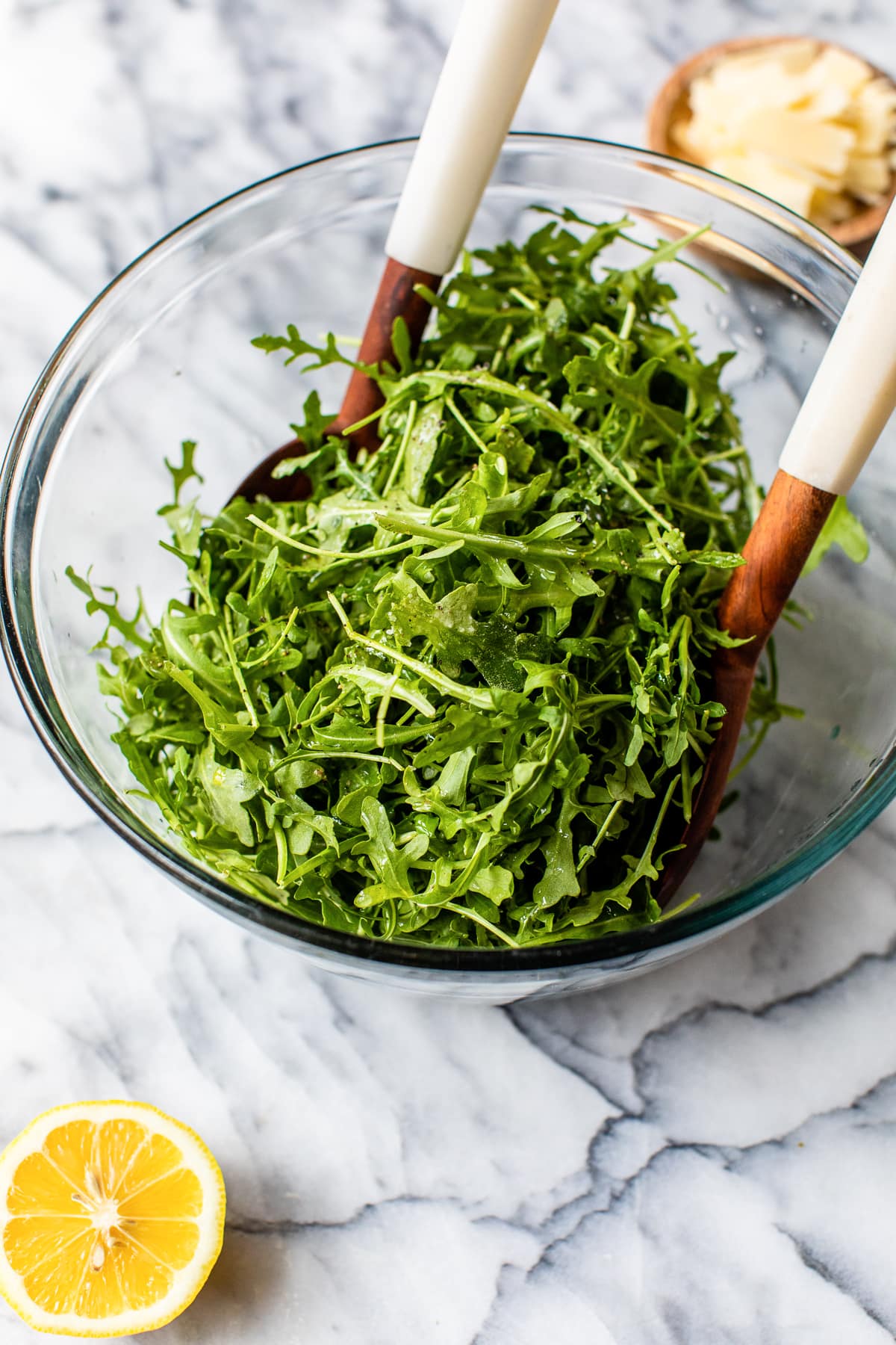 tossing arugula in a bowl