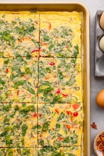 Top-down view of baked, scrambled eggs in a baking sheet.